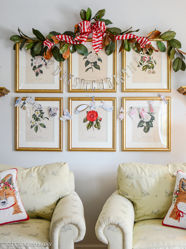 12 Days of Christmas banner hung on camellia prints with magnolia garland above