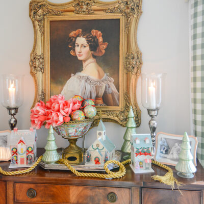 katherine's sideboard decorated with Christmas village houses, "12 days of Christmas" ornaments, amaryllis