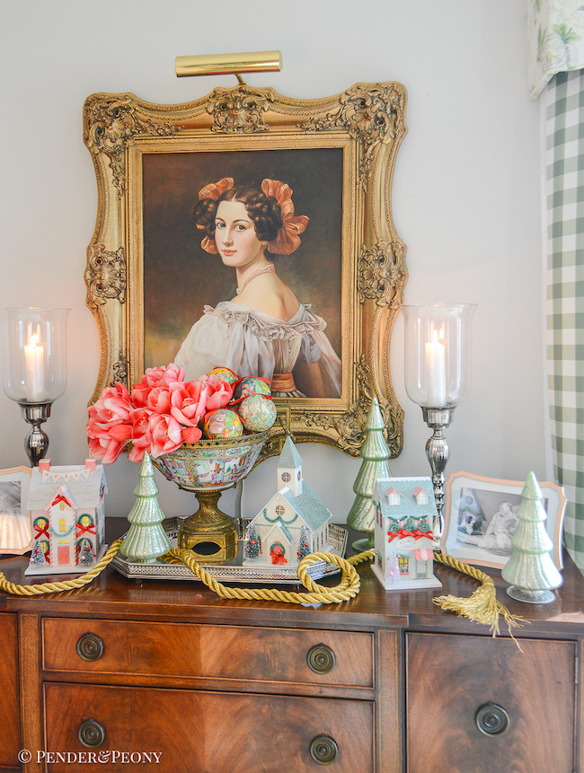 katherine's sideboard decorated with Christmas village houses, "12 days of Christmas" ornaments, amaryllis