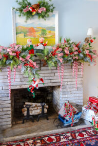 red and white Christmas garland on stone mantel with candy cane striped ribbon and Annalee dolls