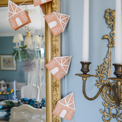 felt gingerbread house garland hangs on mirror