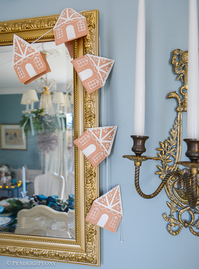 felt gingerbread house garland hangs on mirror