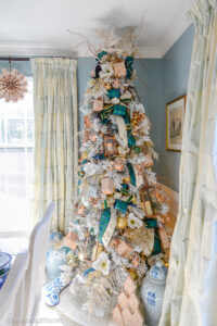 Gingerbread forest Christmas tree decorated with Black Watch plaid and velvet ribbons, copper lanterns, cookie cutters, magnolia, and iced branches