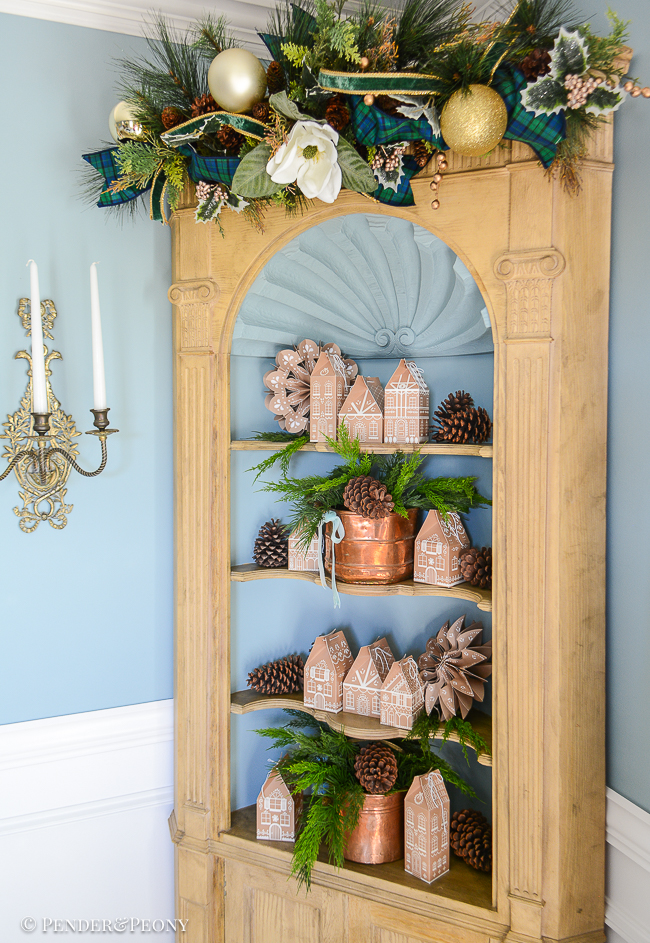 Gingerbread houses on hutch with vintage copper, cedar branches, and pine cones