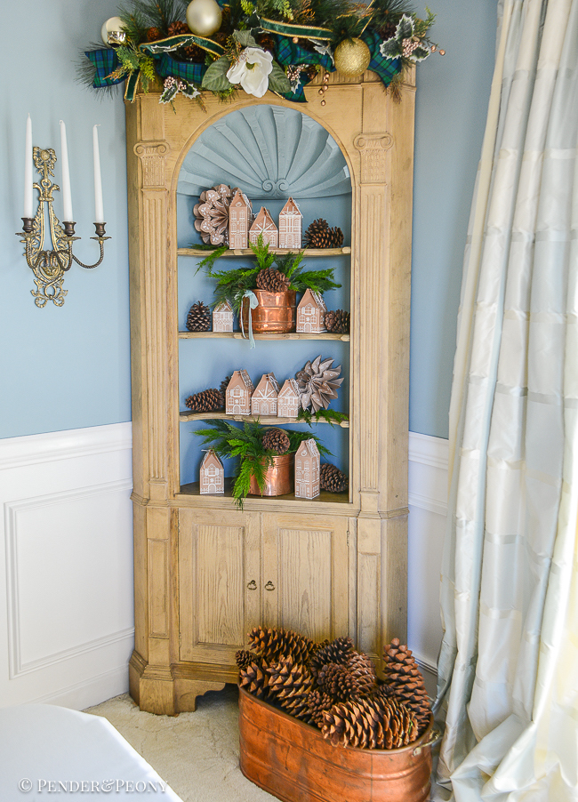 The gingerbread forest Christmas theme continues in the hutch with gingerbread house advent calendar, antique copper, cedar, and paper snowflakes