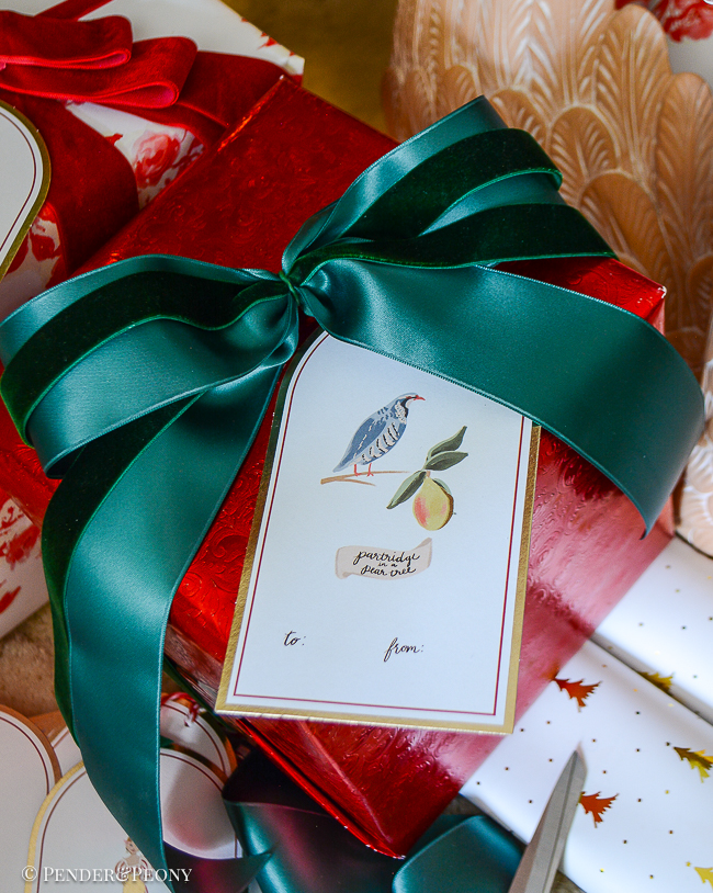 Red wrapped gift with green bow and partridge in a pear tree gift tag