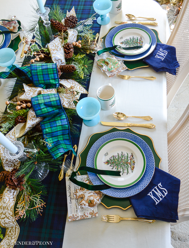 A traditional Christmas tablescape with Black Watch tartan linens, evergreen centerpiece, Spode Christmas china, and gingerbread cookies