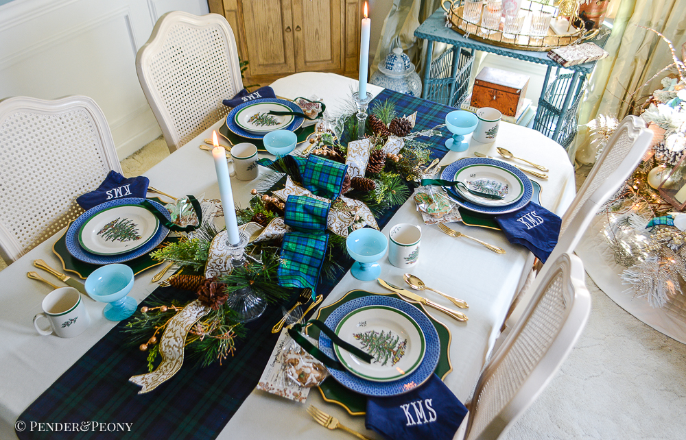 Black Watch tartan table runner layered with evergreen centerpiece, Blue Mottahedeh china, Spode Christmas tree china, and gingerbread cookies for a classic Christmas table idea