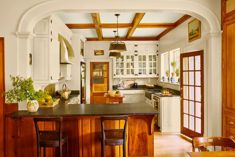 Traditional kitchen with lots of wood and white cabinets, black countertops