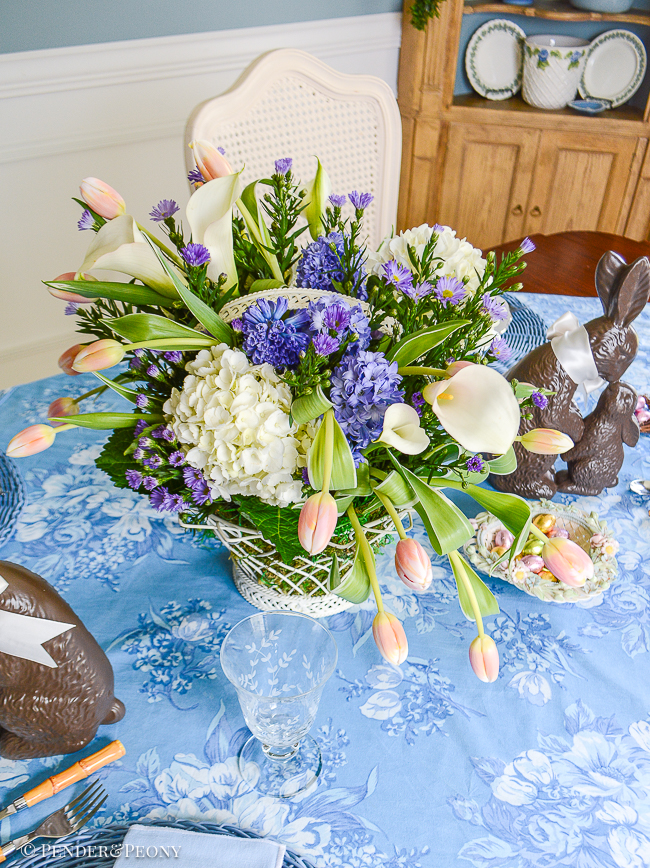 Easter table centerpiece with French wire style basket, tulips, hyacinths, and hydrangea.