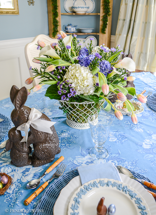 Easter table centerpiece with French wire style basket, tulips, hyacinths, and hydrangea.