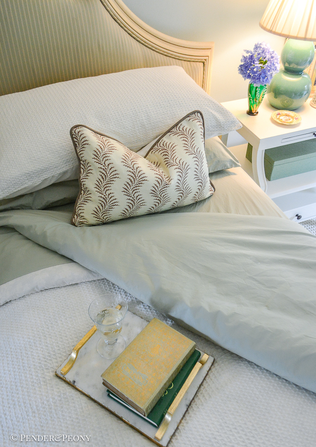 Turned down bed with stack of books and a glass of wine on tray - perfect set up for an afternoon of reading - 2025 Summer Reading List