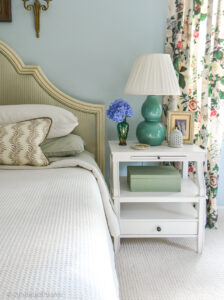 Green and blue master bedroom with white nightstand