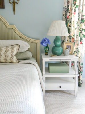 Green and blue master bedroom with white nightstand