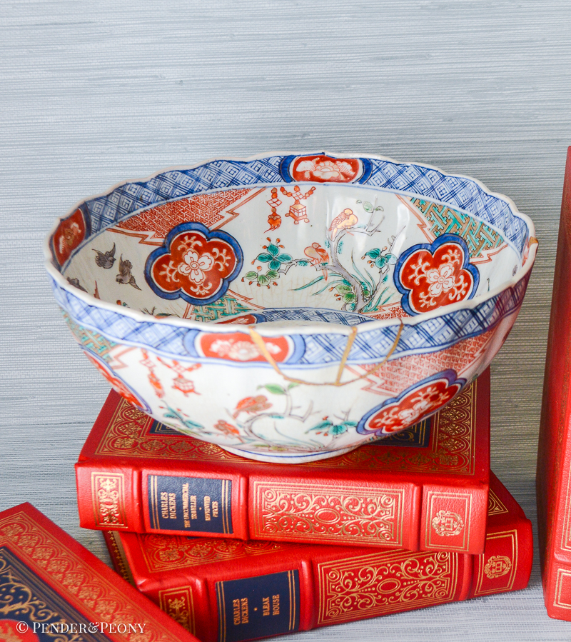 A unique Japanese Imari bowl with gilt repaired rim decorated with scenes of bamboo, birds, flowering trees, and lanterns.