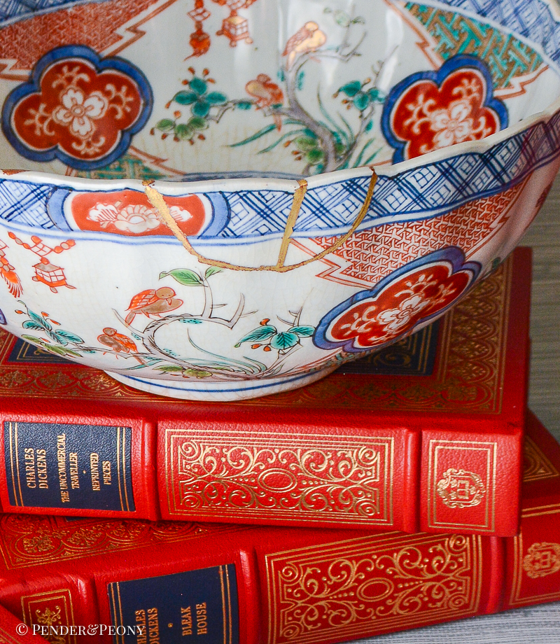 A unique Japanese Imari bowl with gilt repaired rim decorated with scenes of bamboo, birds, flowering trees, and lanterns.