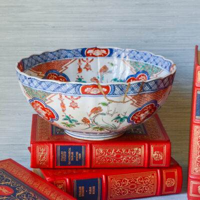 A unique Japanese Imari bowl with gilt repaired rim decorated with scenes of bamboo, birds, flowering trees, and lanterns.