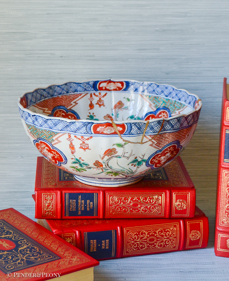 A unique Japanese Imari bowl with gilt repaired rim decorated with scenes of bamboo, birds, flowering trees, and lanterns.