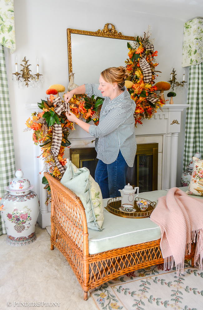 Katherine adjusts brown and white gingham ribbon on fall mantel garland