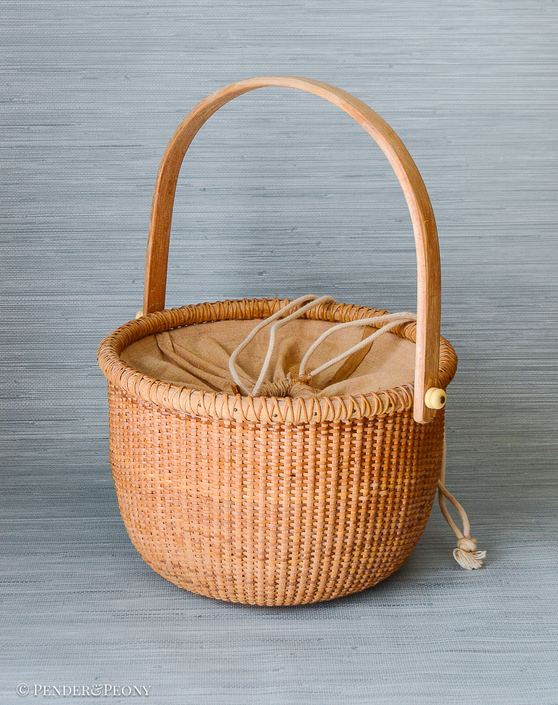 A New England classic basket with handle and cloth lining.