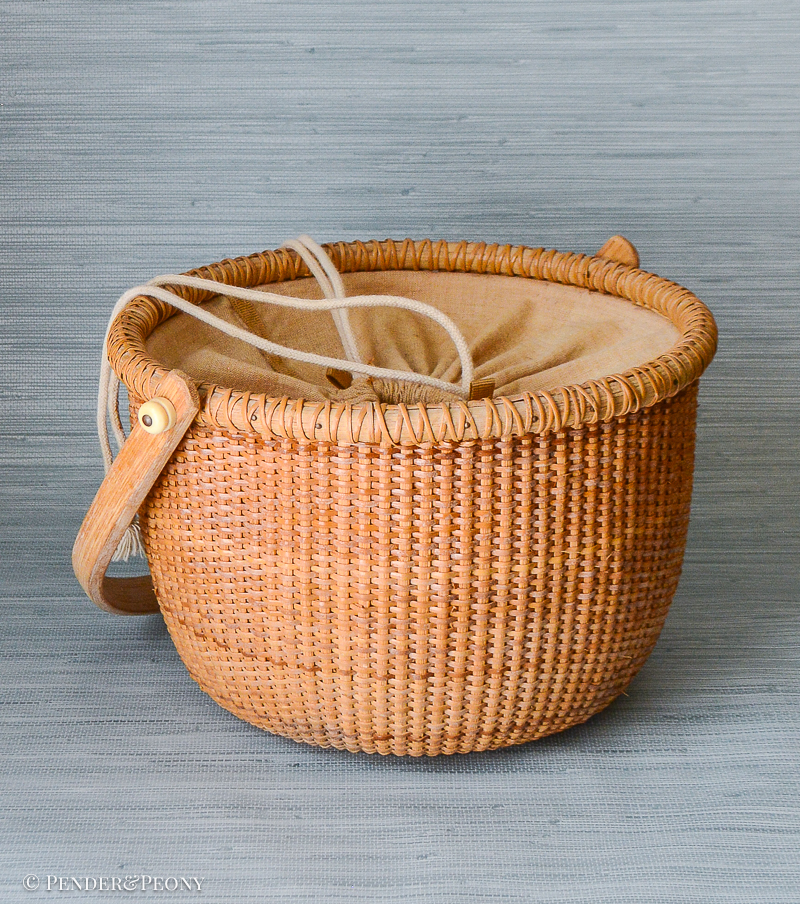 A New England classic basket with handle and cloth lining.