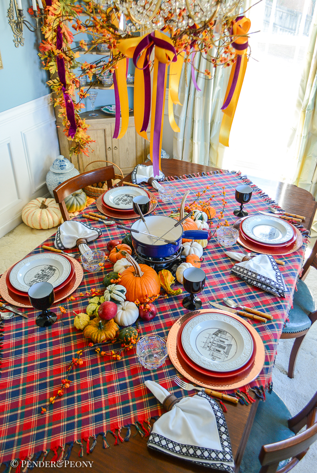 Fall fondue party tablescape set with plaid throw, Mottahedeh creil dishes, copper, Swissmar fondue pot, and Murano glass goblets.