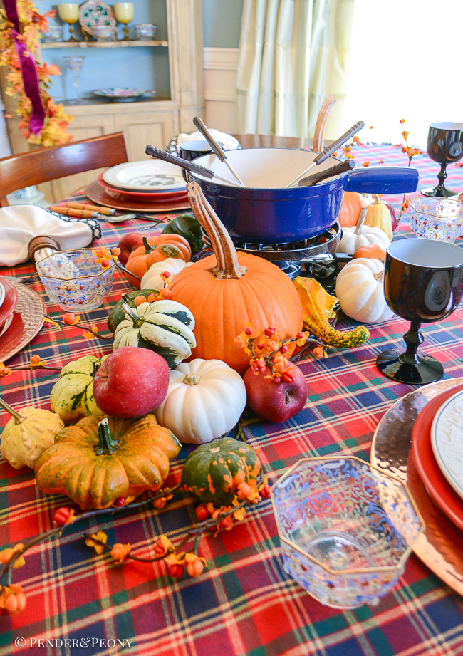Swissmar fondue pot surrounded by pumpkins and gourds for a fall dinner party