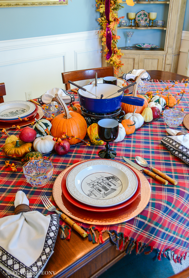 Mottahedeh Creil architecture bowls on top of red dinner plates and copper chargers create a chic setting for this fondue dinner