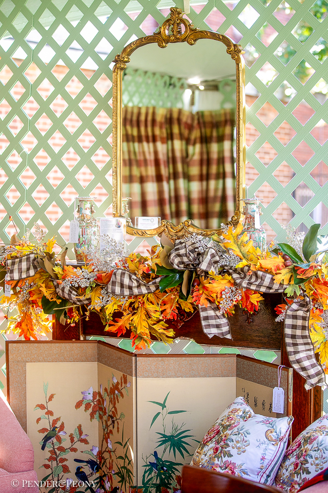 Gold mirror above oak mantel with fall garland decoartion