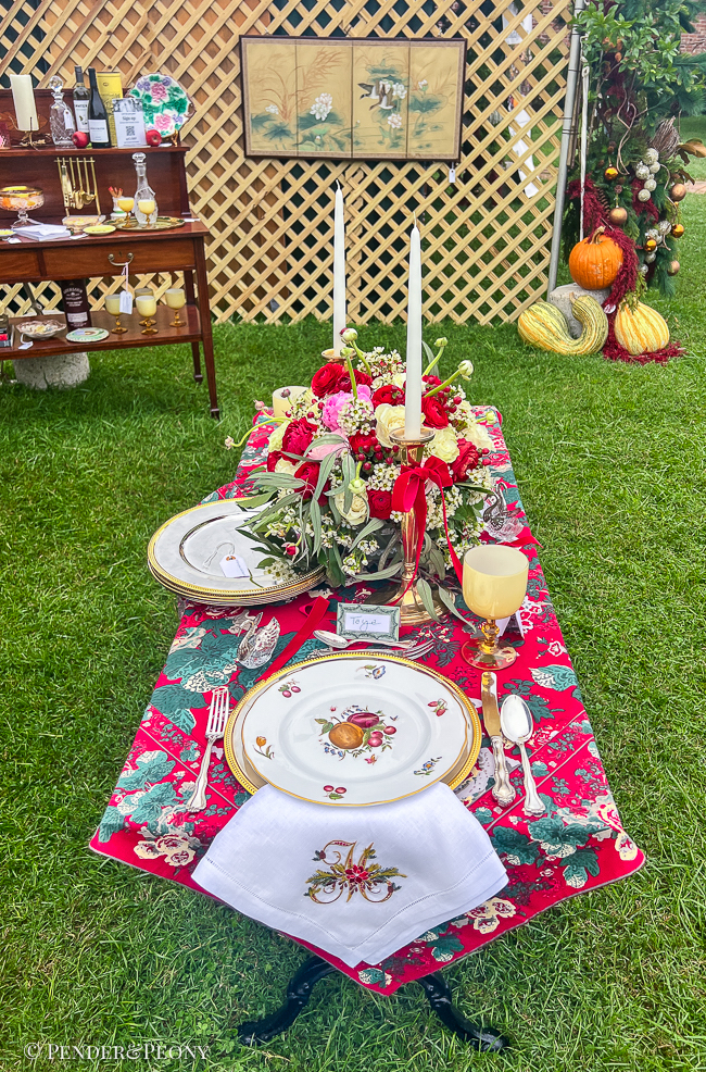 Christmas table decorated with red chintz cloth, Delecta bone china, silver, brass, and peonies