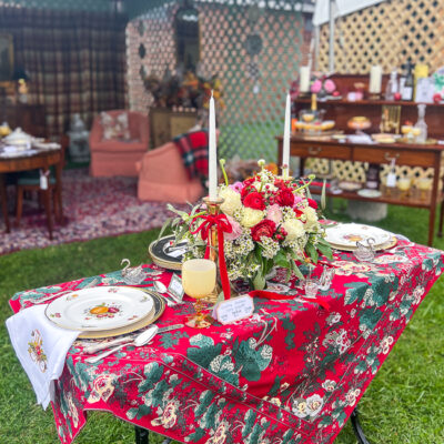 Christmas table decorated with red chintz cloth, Delecta bone china, silver, brass, and peonies
