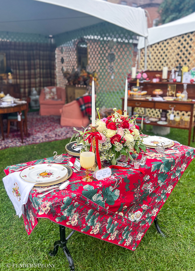 Christmas table decorated with red chintz cloth, Delecta bone china, silver, brass, and peonies