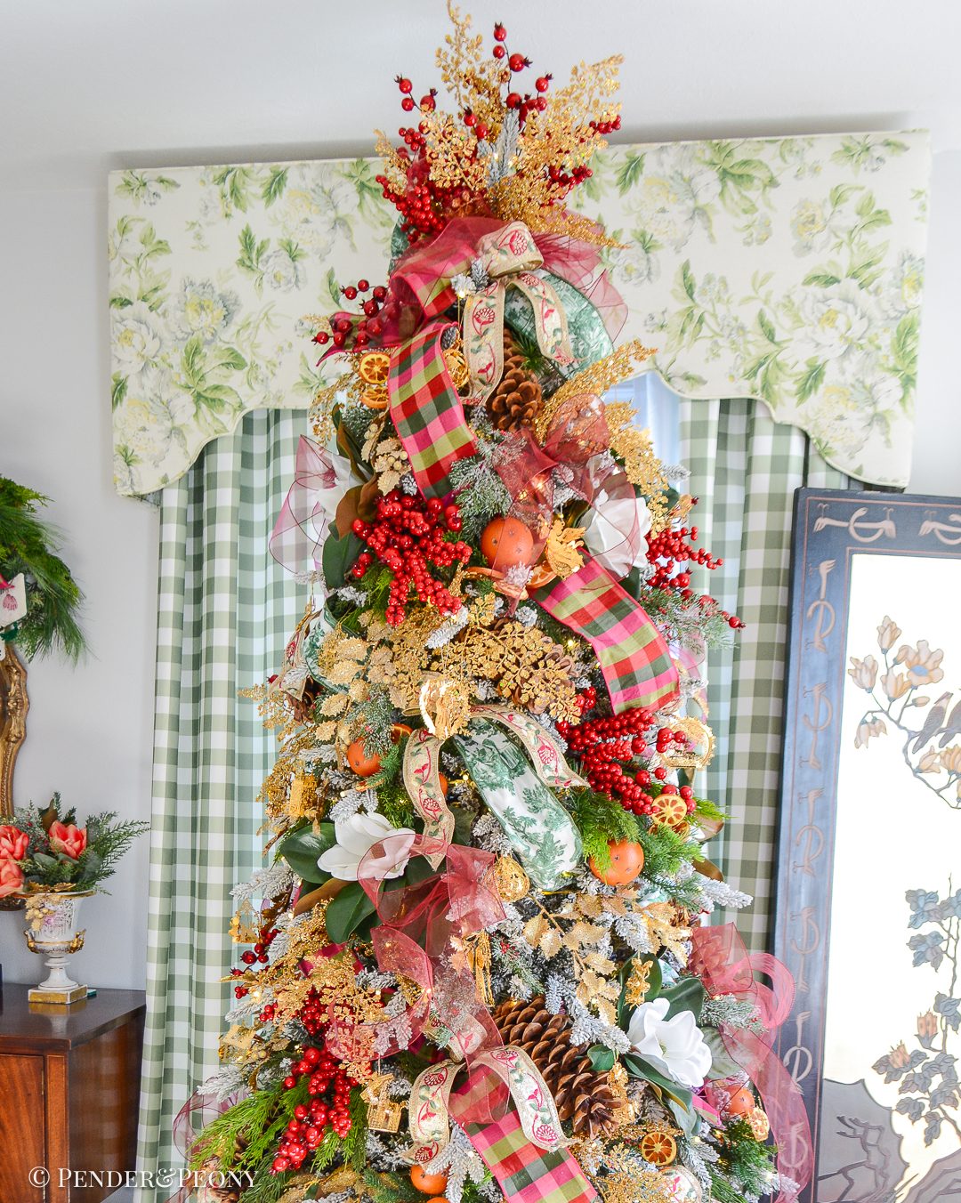 My Christmas tree decorated in the Grand Botanical look with a pink, green, and red color scheme, Danbury Mint gold ornaments, designer ribbons, bows, magnolia, orange pomanders, and joy!