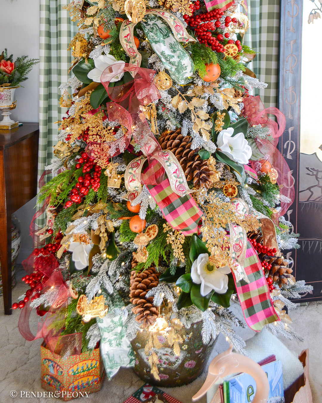My Christmas tree decorated in the Grand Botanical look with a pink, green, and red color scheme, Danbury Mint gold ornaments, designer ribbons, bows, magnolia, orange pomanders, and joy!
