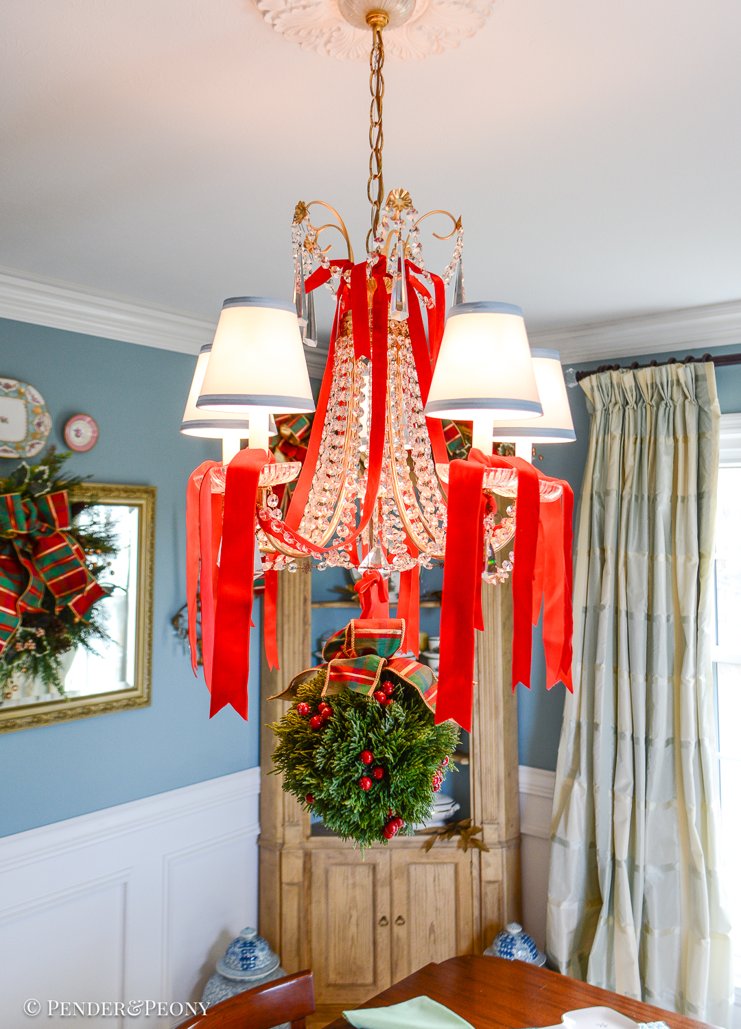 Faux cedar kissing ball with red berries and plaid bow