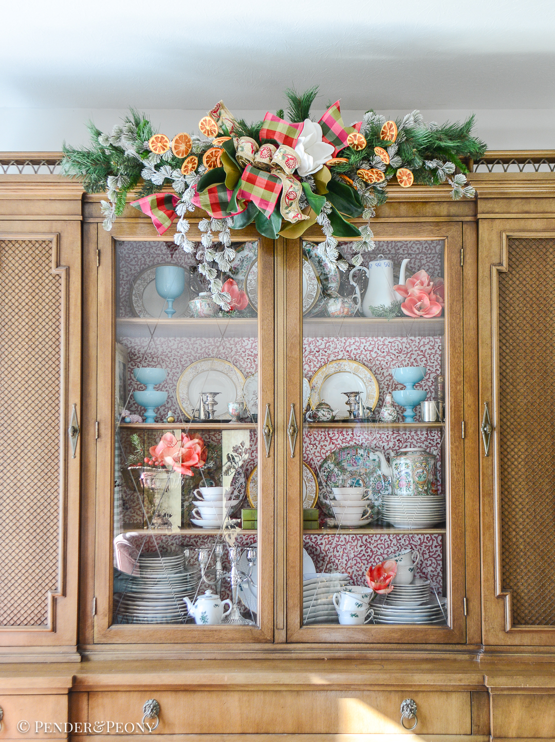 Decorate your bookcase and china cabinet with a swag and florals for Christmas