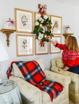 Festive touches to add to your Christmas decorating that make your house feel more merry! Katherine adjusts a magnolia wreath hung over her botanical gallery wall.