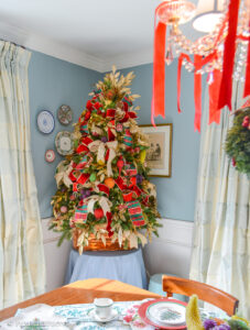 Dining room Christmas tree bedecked with vintage beaded fruit, plaid ribbon, gold laurel, and copper cookie cutters.