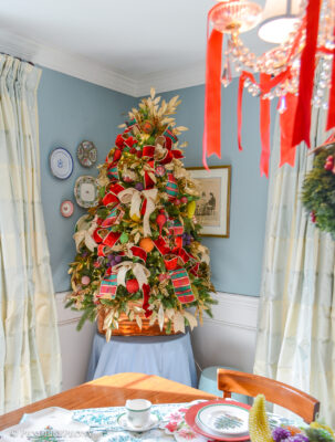 Dining room Christmas tree bedecked with vintage beaded fruit, plaid ribbon, gold laurel, and copper cookie cutters.