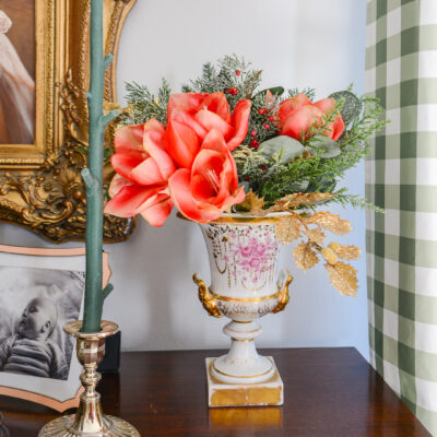 Amaryllis, pine, cedar arranged in Old Paris urn
