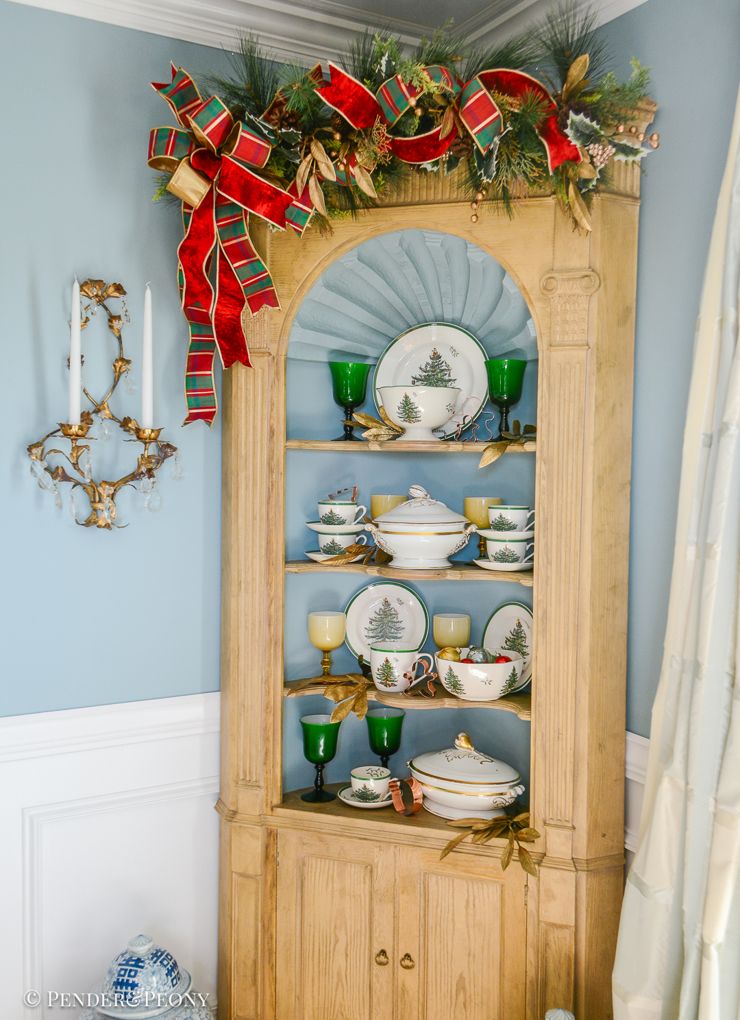 Spode's Christmas tree pattern dishes with antique French china and Murano glasses decorate the corner hutch