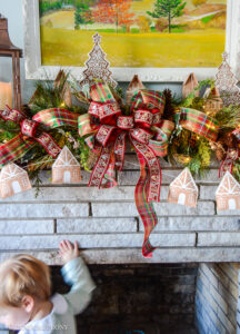 Come explore the fireplace Christmas decorations in our family room where a gingerbread village nestles amongst the holly and pine in this gorgeous garland idea