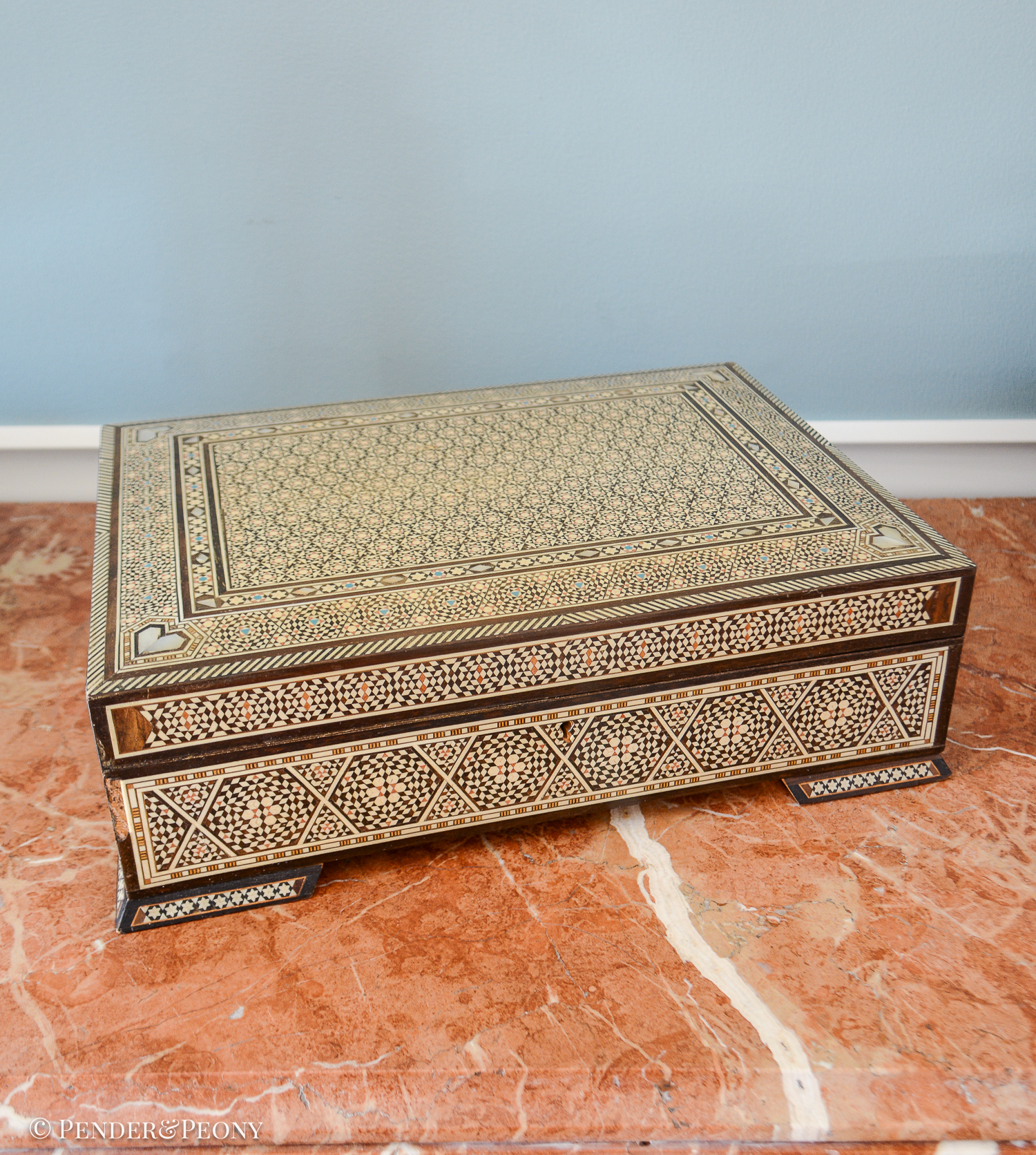 Large vintage dresser box with marquetry inlay of bone, mother of pearl, and a blue material. Red felt interior