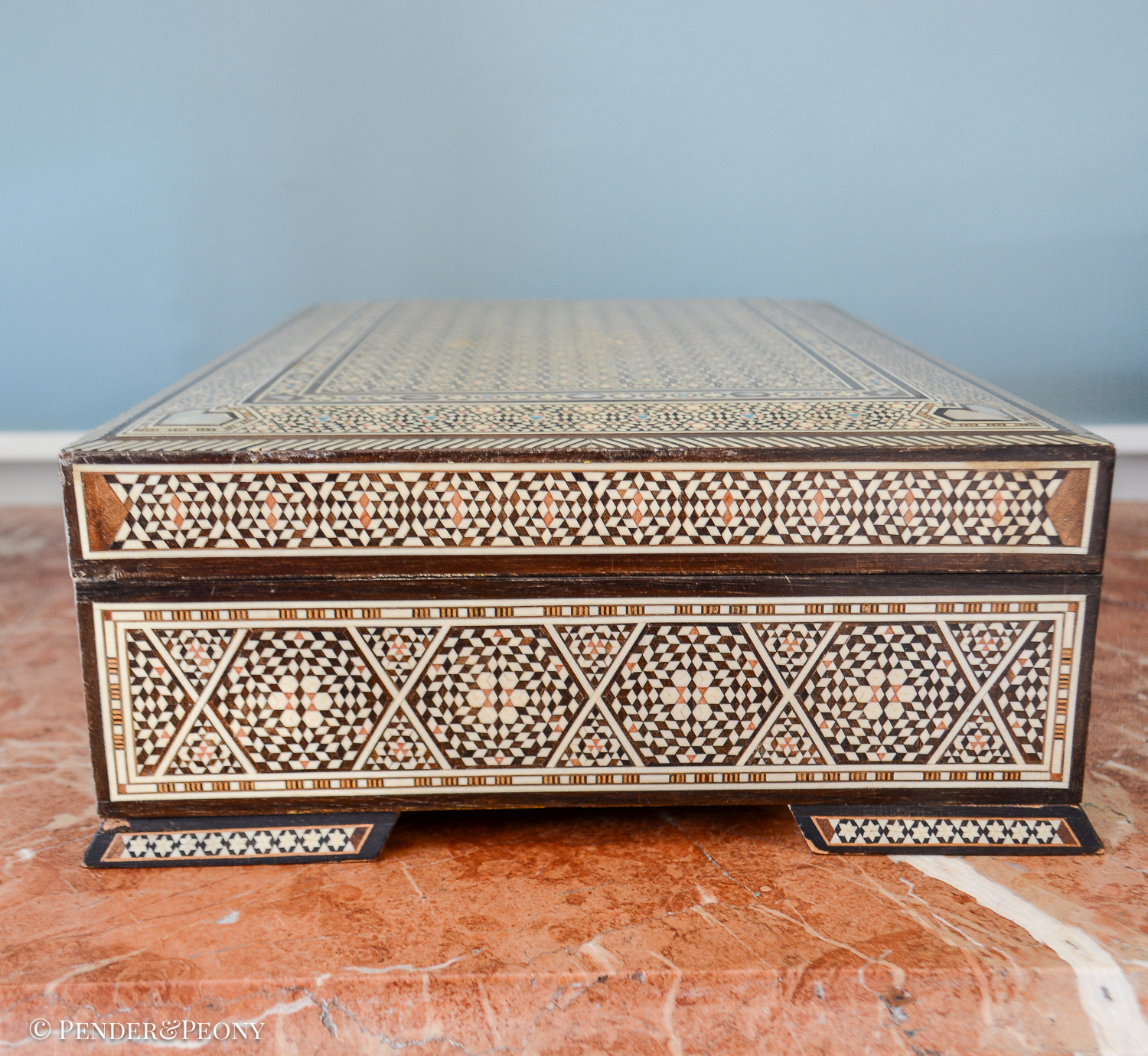 Large vintage dresser box with marquetry inlay of bone, mother of pearl, and a blue material. Red felt interior