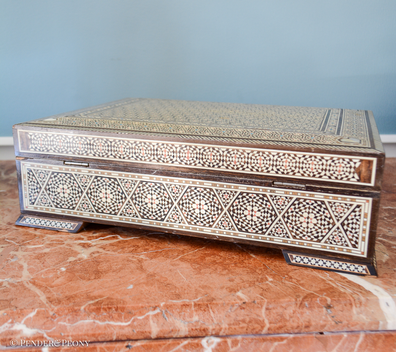 Large vintage dresser box with marquetry inlay of bone, mother of pearl, and a blue material. Red felt interior