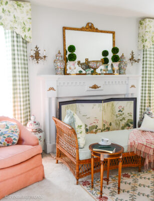 Katherine's collected living room with traditional columned mantel, French gilt mirror, Rose Medallion, and wicker daybed