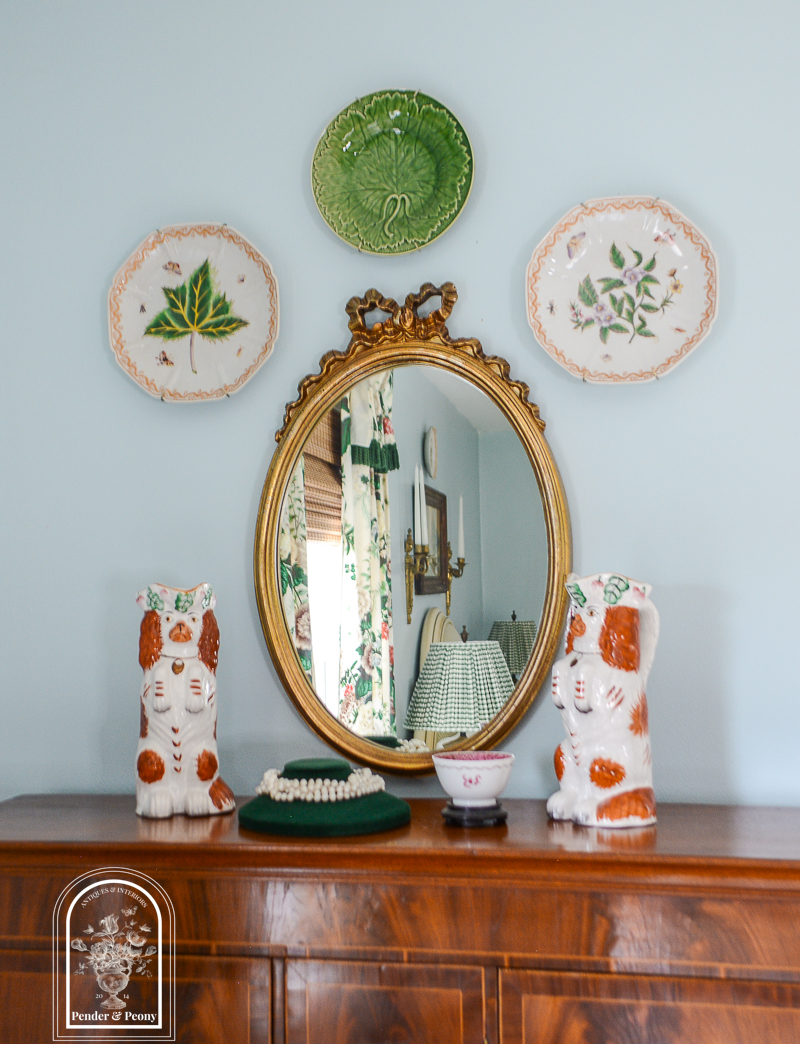 Top of desk decorated with gilt bow mirror, Staffordshire spaniels, and jewelry display