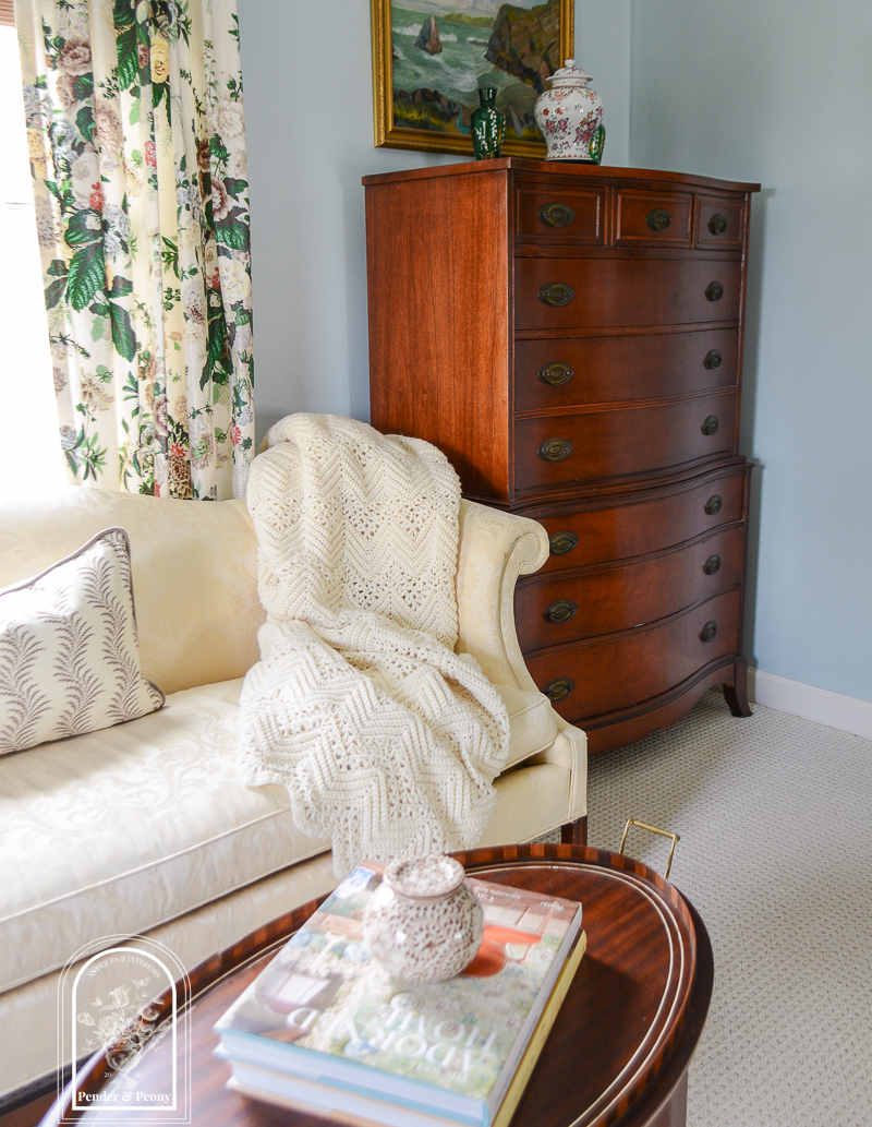 Handmade crochet blanket drapes one end of the ivory damask sofa