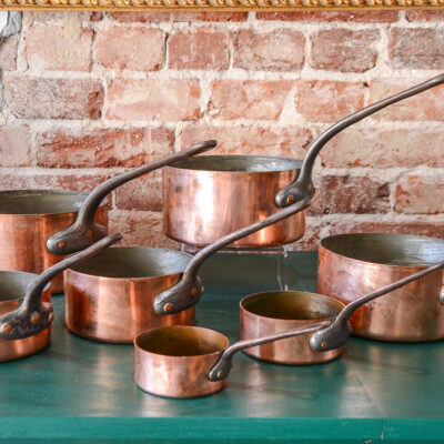 Graduated set of 7 copper saucepans with cast iron handles