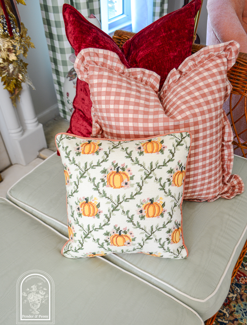 Pillow pile for fall decorating: pumpkin needlepoint, pink check with ruffle, burgundy chenille